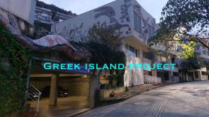 znak na budynku z napisem „grecka wyspa, projekt wyspy” w obiekcie Greek island Project w Tiranie