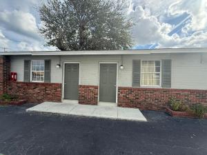 Holly HillRollie's Motel Daytona Beach by Hotel O的两扇门和砖墙的房子