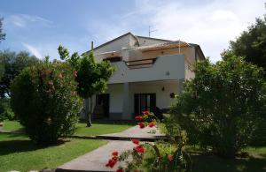 a white house with trees and flowers in the yard at I Profumi Dell'Orto - Campagnatico in Preselle