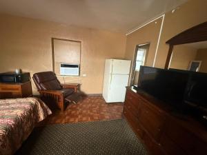 Una televisión o centro de entretenimiento en Rollie's Motel Daytona Beach by Hotel O