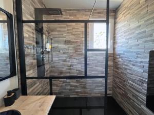 拉特斯Évasion Chic - Duplex 70 m2 climatisé avec terrasse et parking的砖墙间的一个淋浴 更多14张照片