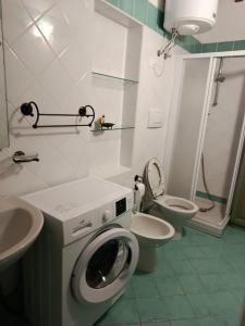 a bathroom with a washing machine and a toilet at Podere Casalpiano Alloggio Estivo VENTURINA TERME BARATTI POPULONIA Bella Tuscany in Casa Banditelle