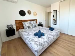 拉特斯Évasion Chic - Duplex 70 m2 climatisé avec terrasse et parking的卧室里有一张大床，配有蓝色枕头