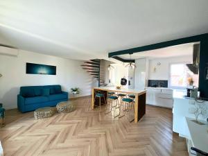 拉特斯Évasion Chic - Duplex 70 m2 climatisé avec terrasse et parking的带蓝色沙发的客厅和厨房