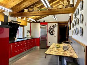纳瓦夫里亚La Hacienda De Navafria的一间厨房,里面装有红色橱柜和一张桌子