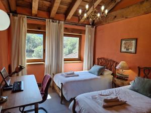 纳瓦夫里亚La Hacienda De Navafria的一间卧室，有两张床、一张桌子和一张书桌 更多37张照片