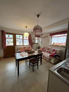 un soggiorno con un tavolo e un divano di Tabià Padola a Comèlico Superiore