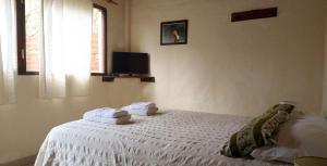a bedroom with a white bed with towels on it at Complejo Casa Caracolnegro in Mar de Cobo
