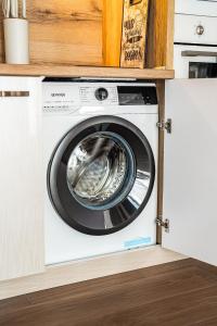 a washing machine in a kitchen under a cabinet at Best Central Lux Studio in Bansko