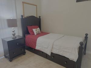 a bedroom with a bed with a red pillow and a night stand at Cozy 2-Bed Guest Room Convenient Location in Tracy