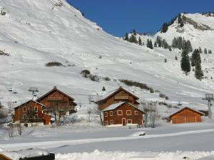 a group of buildings in the snow next to a mountain at Studio central au Praz de Lys, 4 pers, proche pistes - FR-1-815-18 in Le Praz de Lys