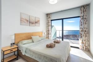 a bedroom with a bed and a large window at Sanset Waves with a sea view! in Benidorm +25 photos