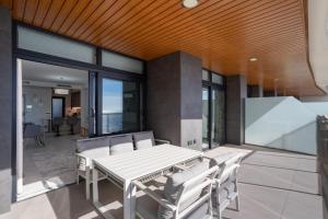 a dining room with a white table and chairs at Sanset Waves with a sea view! in Benidorm