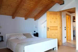 费德拉帕加内拉Casa Solaris的卧室里有一张白色的床和木质天花板