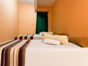 two beds in a room with green curtains at Hotel Coutinho PIO XII in Pirapora +21 photos