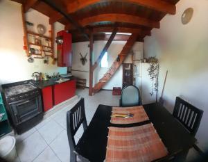 una cucina con tavolo da pranzo e una cucina con armadi rossi di Departamento en Gualeguaychu a Gualeguaychú