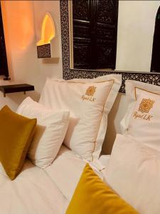 a pile of pillows sitting on a bed at Ryad Lalla khadija in Marrakech