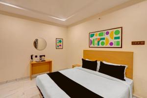 a bedroom with a large bed in a room at Super Townhouse SP Living Tree in Karīmnagar