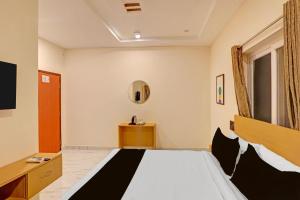 a hotel room with a bed and a mirror at Super Townhouse SP Living Tree in Karīmnagar +21 photos