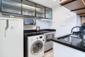 una cocina con lavadora y fregadero en Apto 1 Dormitorio en el Centro de Floripa EFO0603, en Florianópolis 3 fotos más
