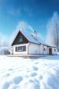 a white house with a roof in the snow at Domov na horách - Krkonoše - horký sud, pergola, dětské hřiště - celý dům in Mřičná