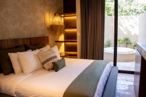 图卢姆Peregrina Tulum 102A 2BR Luxury Condo的一间卧室，配有一张大床和一扇大窗户。