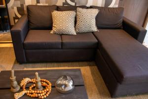 图卢姆Peregrina Tulum 102A 2BR Luxury Condo的客厅里有一张棕色沙发，沙发上放着一串念珠。 更多43张照片