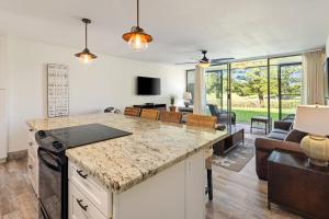 a kitchen with a counter top and a living room at Tee and Sea Getaway ay Turtle Bay in Kahuku