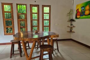 a wooden table and chairs in a room with windows at Casa Andrew - Cozy Island Home in Santa Cruz