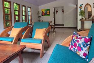 a living room with blue chairs and a table at Casa Andrew - Cozy Island Home in Santa Cruz