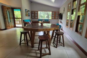 a dining room with a wooden table and stools at Casa Andrew - Cozy Island Home in Santa Cruz +29 photos