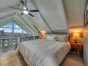 a bedroom with a white bed and a ceiling fan at Lookout Lodge in Beech Mountain