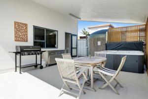 a kitchen with a table and chairs and a grill at Seaside Premium Home with Spa Pool near Beach in Beachlands