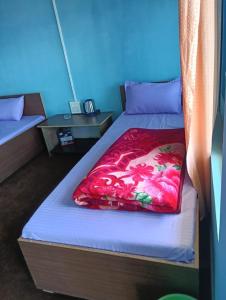 a bedroom with a bed with a red blanket at Susanta Homestay , Icchegaon , Kalimpong in Kalimpong