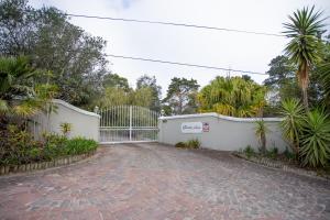 una entrada con una valla blanca y palmeras en Slanting Acers - Unit B, en Wilderness 12 fotos más