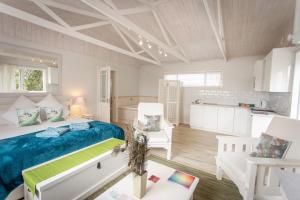 Un dormitorio con una cama y dos sillas blancas. en Slanting Acers - Unit B, en Wilderness