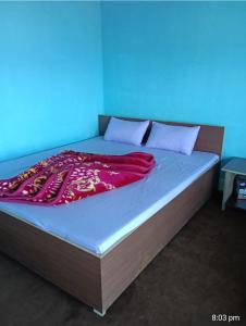 a bed with a red blanket on top of it at Susanta Homestay , Icchegaon , Kalimpong in Kalimpong
