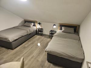 2 Betten in einem kleinen Zimmer mit 2 Tischen in der Unterkunft Hostel P16 in Zagreb