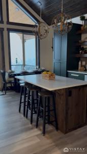 a kitchen with a table and stools in a room at The Wandering Doe Readers Retreat with Hot Tub in Long Valley Junction