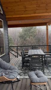 a deck with a picnic table and chairs on a porch at The Wandering Doe Readers Retreat with Hot Tub in Long Valley Junction
