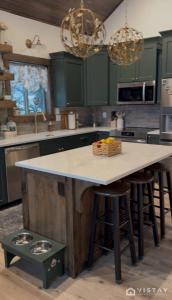 a kitchen with green cabinets and a white counter top at The Wandering Doe Readers Retreat with Hot Tub in Long Valley Junction
