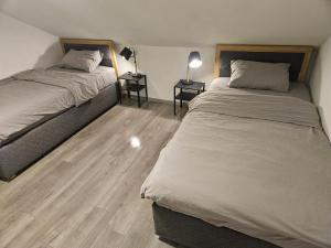 2 Betten in einem Zimmer mit 2 Tischen und 2 Lampen in der Unterkunft Hostel P16 in Zagreb + 9 Fotos