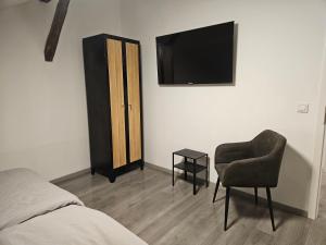ein Schlafzimmer mit einem Stuhl und einem TV an der Wand in der Unterkunft Hostel P16 in Zagreb