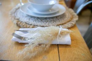 ein Holztisch mit einem Teller, einer Gabel und einem Becher in der Unterkunft Rooemah Lodge - Grampian Lettings in Caskieben