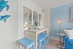une cuisine avec une table et deux tabourets bleus dans l'établissement Beach Cove Resort Oceanfront Unit 314 with Balcony, à Myrtle Beach