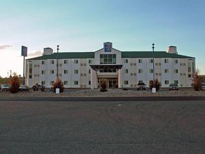 落基山的住宿－落基山6號汽車旅館，一座白色的大建筑,设有绿色屋顶