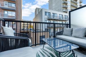 balcone con divano e tavolo in vetro di Pristine Parc Avenue Pad With Parking a Montréal