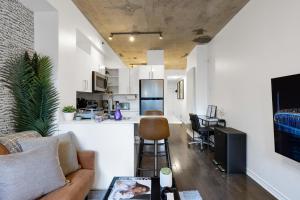 un soggiorno con divano e cucina di Pristine Parc Avenue Pad With Parking a Montréal
