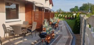 a patio with a table and chairs and plants at Nautica in Gąski