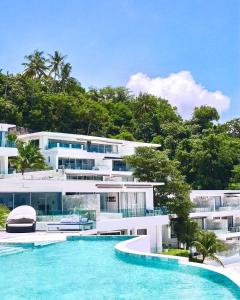 eine Außenansicht eines Gebäudes mit einem Swimmingpool in der Unterkunft The View Kata Karon in Kata Beach
